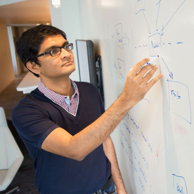 A researcher writing on a whiteboard